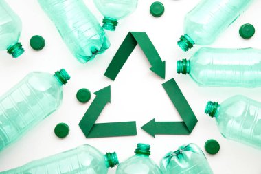 Boş plastik su şişeleriyle yeşil kağıt geri dönüşüm sembolü