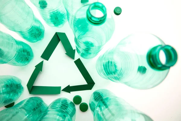 Simbol daur ulang kertas hijau dengan botol air plastik kosong — Stok Foto