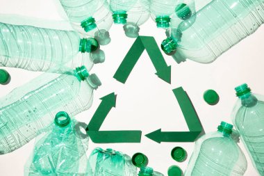 Boş plastik su şişeleriyle yeşil kağıt geri dönüşüm sembolü