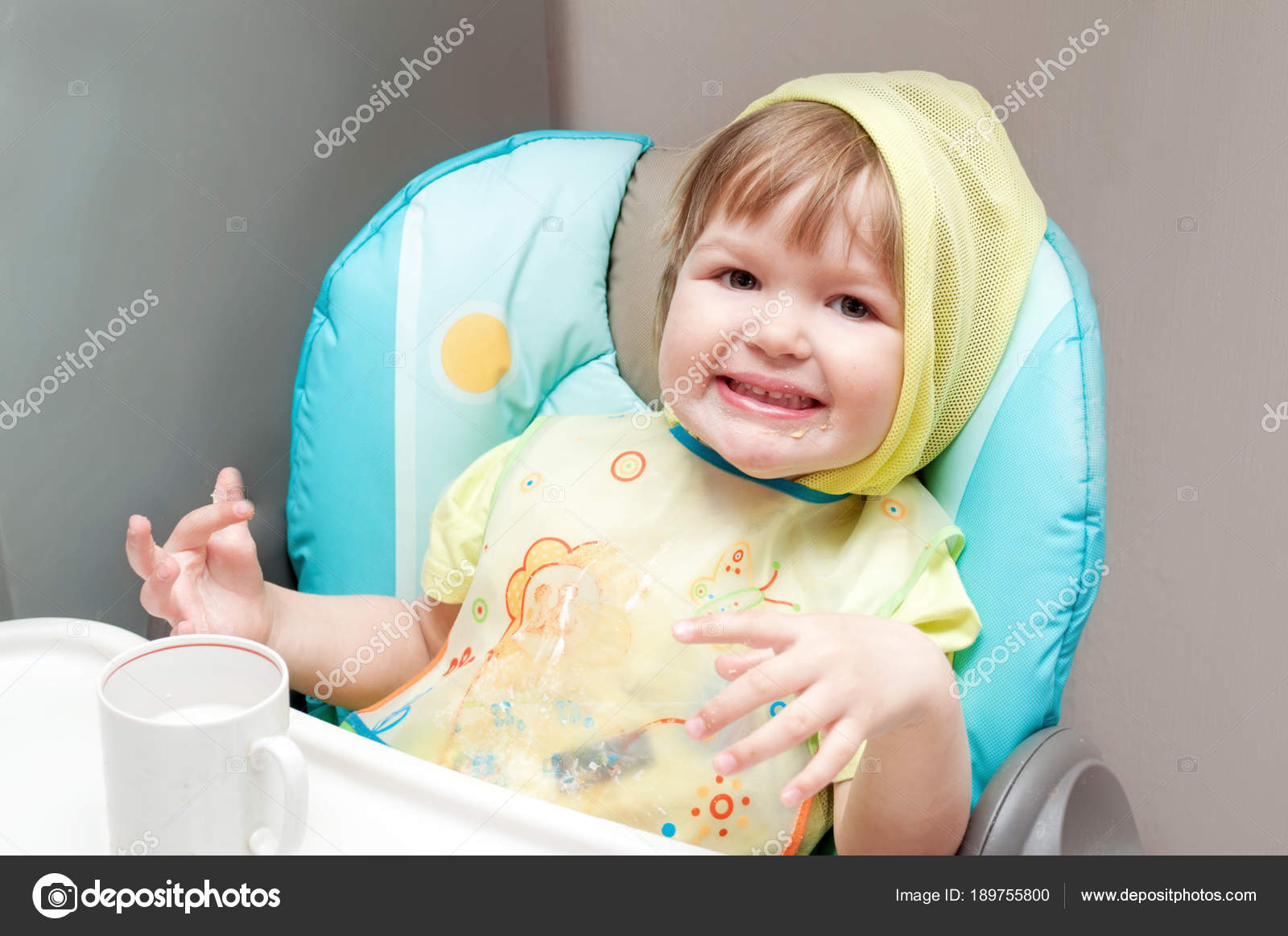 Little One Year Old Baby Girl Is Eating At The Highchair Stock