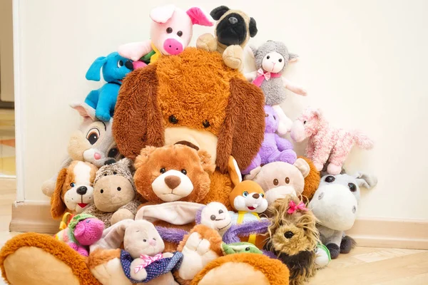 Many Soft plush fluffy toys sits on the floor in the children\'s room