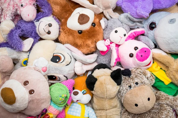 Many Soft plush fluffy toys sits on the floor in the children's room