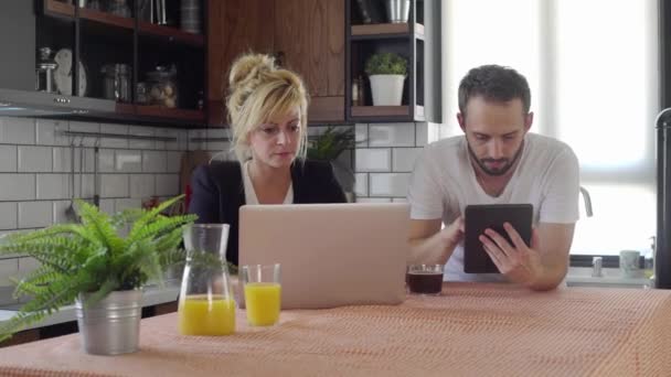 丈夫和妻子在喝咖啡休息的时候上网搜寻 并在厨房得到了一个好消息 — 图库视频影像