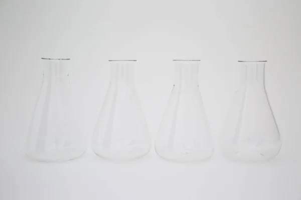 Beyaz arka planda izole edilmiş bir grup bilimsel cam Erlenmeyer şişesi. — Stok fotoğraf