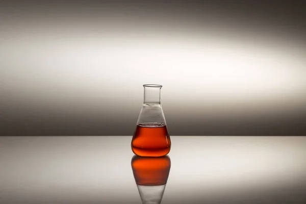 科学实验室的玻璃瓶，装有反光表面的红色液体. — 图库照片