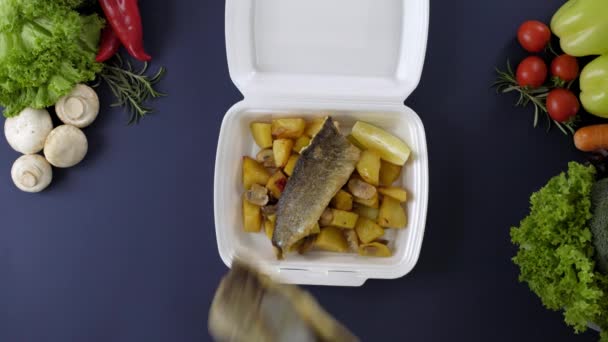 発泡スチロール製の箱に持ち帰り用の食品を詰めます 魚やジャガイモと新鮮な配達パックの食事 — ストック動画