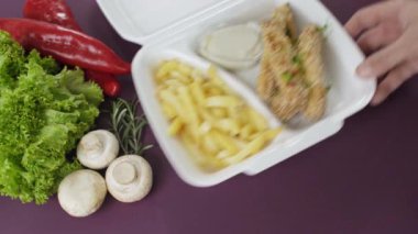 Köpük kutusunda paket yiyecek paketliyorum. Tavuk nugget ve patates kızartmasıyla taze paket yemek. 