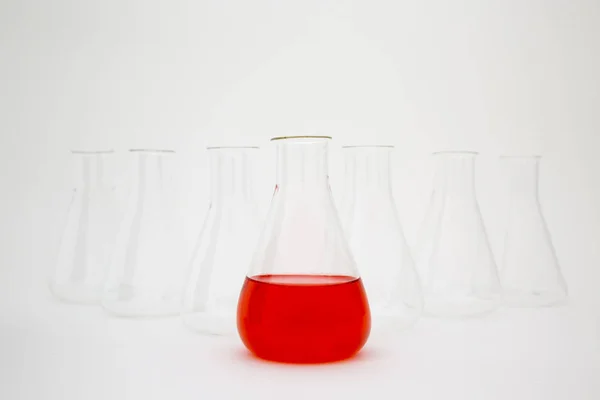 Bilimsel laboratuvar camı Erlenmeyer şişesi kırmızı sıvıyla dolu beyaz arka planda cam ekipman.. — Stok fotoğraf
