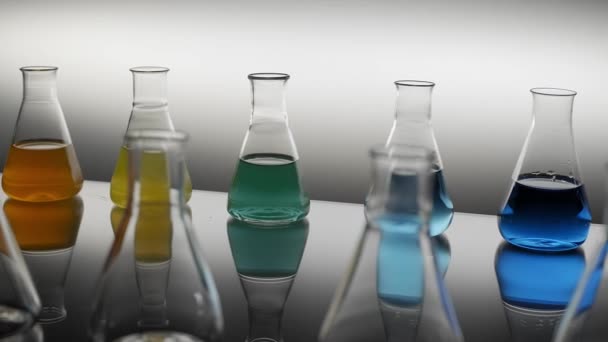Empty Mixed Color Liquid Filled Erlenmeyer Flasks Reflecting Table — Stock Video