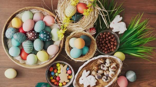 Tollak esnek színes húsvéti tojások fészekben és tavaszi virágok fa asztalon. Húsvéti ünnepi dekorációk, húsvéti koncepció háttér.