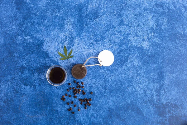 Cannabis soap, CBD oil and coffee beans on dark blue background. Medicinal marijuana in cosmetics.