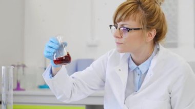 CBD petrolüyle çalışan bilim adamlarına yakın çekim. Laboratuvarda kenevir CBD ve CBDA yağı ile çalışan kimya bilimcilerini kapatın. Erlenmeyer matarası kullanıyor. Esrar eczacılık sağlık hizmeti kavramı.