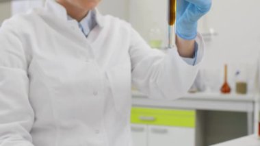 CBD petrolüyle çalışan bilim adamlarına yakın çekim. Laboratuvarda kenevir CBD ve CBDA yağı ile çalışan kimya bilimcilerini kapatın. Erlenmeyer matarası kullanıyor. Esrar eczacılık sağlık hizmeti kavramı.