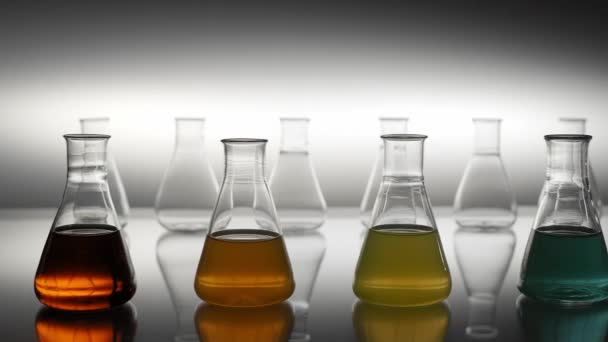 Empty Mixed Colour Liquid Filled Erlenmeyer Flasks Reflecting Table — Stock Video