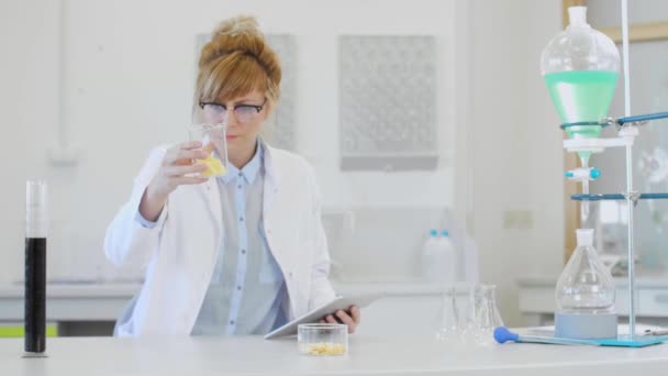 実験室で麻テンペ結晶を検査する女性化学者 大きな麻テルペン酸結晶は 実験室で時計ガラス上に配置されています 化学者保持タブレット — ストック動画