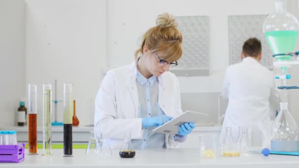 两名科学家在实验室研究大麻Cbd和Cbda油和石碑 他们用的是胶乳手套 玻璃管和橡皮瓶 大麻籽保健药品 — 图库视频影像