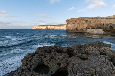 Gozo Malta 'da deniz manzaralı kayalar ve su