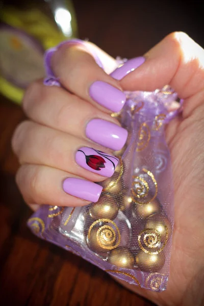 Uñas color lila en el fondo de la bolsa con las joyas —  Fotos de Stock