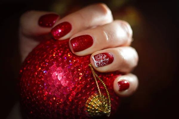 New Year red ball and bright nails in tone — Stock Photo, Image