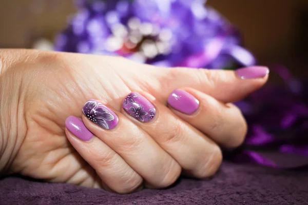 Hermosa manicura con un patrón de lila —  Fotos de Stock