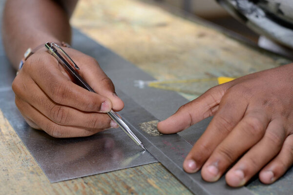 Craftsman working in workshop with scribing needle