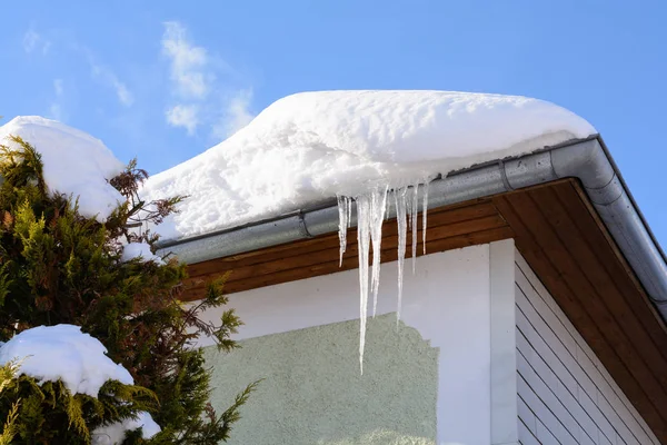 Icículos y nieve en el techo de una casa —  Fotos de Stock