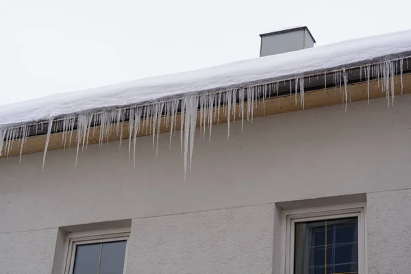 Icículos y nieve en el techo de una casa —  Fotos de Stock