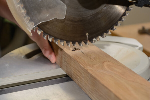 Craftsman cuts with saw - close-up