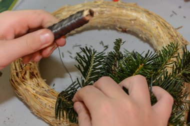 Kişi Advent çelenk bağlar
