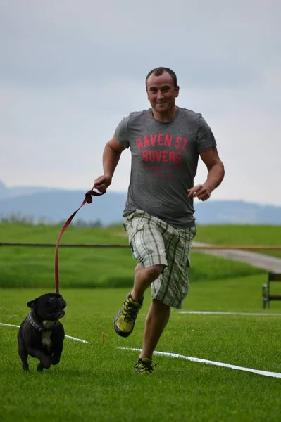 Giovane uomo che fa jogging con il cane piccolo — Foto Stock