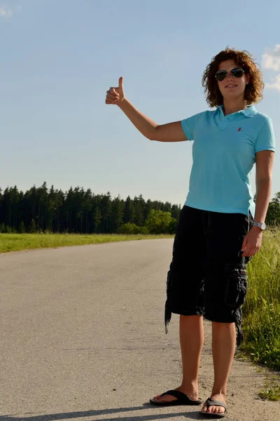 Young woman standing by the roadside — Stock Photo, Image