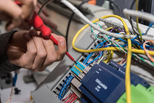 Eletricista trabalha com chave de fenda — Fotografia de Stock