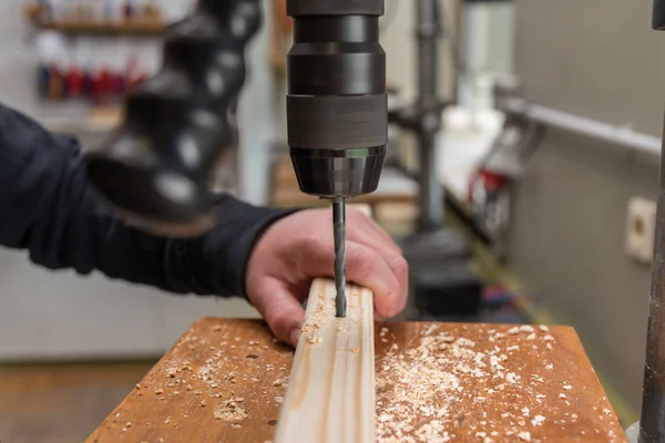 Taladro con un taladro en un agujero de madera —  Fotos de Stock