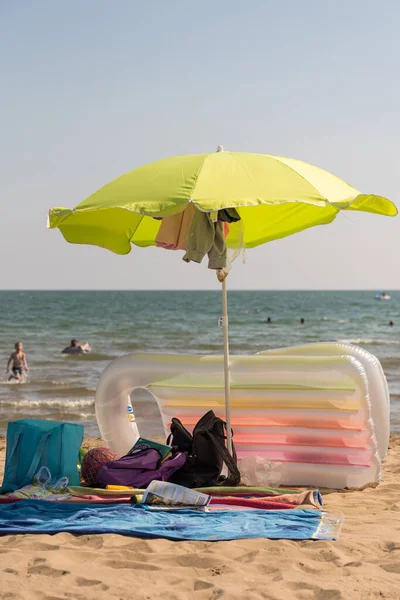 带着雨伞和气垫在沙滩和海上度假 — 图库照片