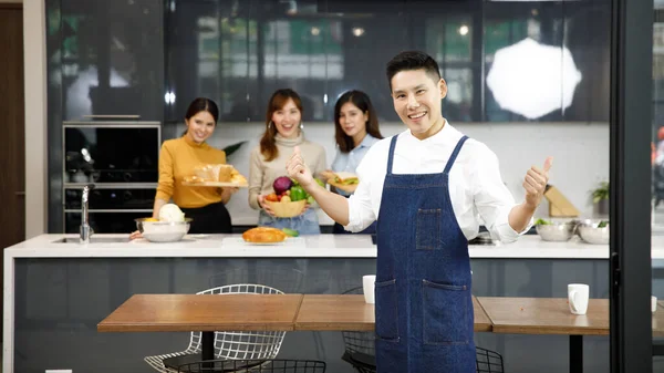 Portrait chefs in kitchen with staff in modern kitche