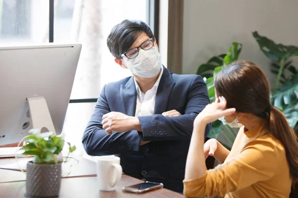 Bussinessman and Businessman workers meeting together with laptop and wear protective masks prevent PM 2.5 and corona virus or covid19 at co working space .Health and teamwork concept