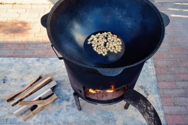 Ulusal Özbek tabak pilav, pilav, plov, pirinç büyük tavada et. Bir kazan açık ateş üzerinde pişirme. Yavaş yavaş bir kepçe hazırlık aşamaları ile karıştırın. Koyun eti yağ için bir koşul kraker kavurma