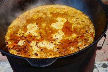 Ulusal Özbek tabak pilav, pilav, plov, pirinç büyük tavada et. İşlem, açık ateş yemek. Bir kazan ateş üzerinde pişirme. Yavaş yavaş bir kepçe ile karıştırın.