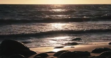 Kumlu sahilde günbatımı, taş, kum, dalgalar, kimse, bir manzara, huzur, bir deprem dalgası ile güneş düşüyor