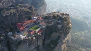 Manastır Trinity 'nin havadan görünüşü ve gün batımında Meteora vadisi ve tarihi kanyonunun nefes kesici resimleri, Kalambaka, Yunanistan, gölgeler, çarpık yol, köprü, dağlar sütun olarak kullanılıyor