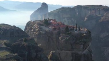 Manastır Trinity 'nin havadan görünüşü ve gün batımında Meteora vadisi ve tarihi kanyonunun nefes kesici resimleri, Kalambaka, Yunanistan, gölgeler, çarpık yol, köprü, dağlar sütun olarak kullanılıyor