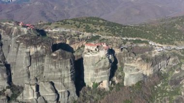 Kalambaka, Yunanistan, Varlaam manastırının havadan görünüşü ve gün doğumunda Meteora vadisi ve tarihi kanyonunun nefes kesici resimleri, bir ipte beşik, bir sürü turist, kırmızı manastır çatıları