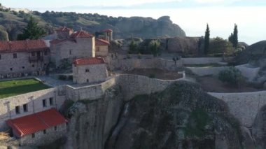 Manastır Trinity 'nin havadan görünüşü ve gün batımında Meteora vadisi ve tarihi kanyonunun nefes kesici resimleri, Kalambaka, Yunanistan, gölgeler, çarpık yol, köprü, dağlar sütun olarak kullanılıyor