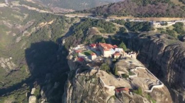 Manastır Trinity 'nin havadan görünüşü ve gün batımında Meteora vadisi ve tarihi kanyonunun nefes kesici resimleri, Kalambaka, Yunanistan, gölgeler, çarpık yol, köprü, dağlar sütun olarak kullanılıyor