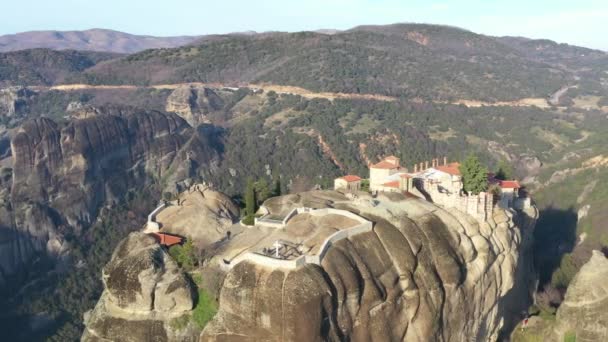 Luftaufnahme des Klosters Trinity und atemberaubende Bilder von Tal und Wahrzeichen Canyon von Meteora bei Sonnenuntergang, Kalambaka, Griechenland, Schatten, verwinkelte Straße, Brücke, Berge als Säulen — Stockvideo