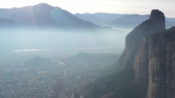 Vista aérea do monumento da Unesco Meteora, as montanhas, o marco da Grécia, tempo ensolarado, neblina, neblina sobre um vale — Vídeo de Stock