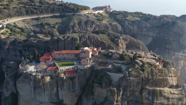 Aerial view of monastery Trinity and breathtaking pictures of valley and landmark canyon of Meteora at sunset, Kalambaka, Greece, shadows, twisted road, bridge, Mountains as columns — Stock Video