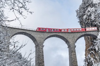 Landwasser Viaduct, kışın kırmızı renkli ünlü tren, İsviçre 'nin simgesi, kar yağışı, Buzul Ekspresi