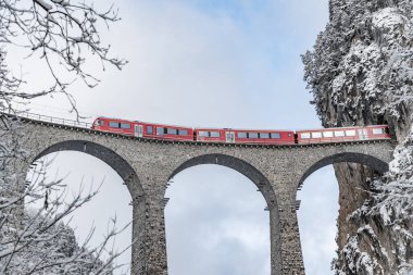 Landwasser Viaduct, kışın kırmızı renkli ünlü tren, İsviçre 'nin simgesi, kar yağışı, Buzul Ekspresi