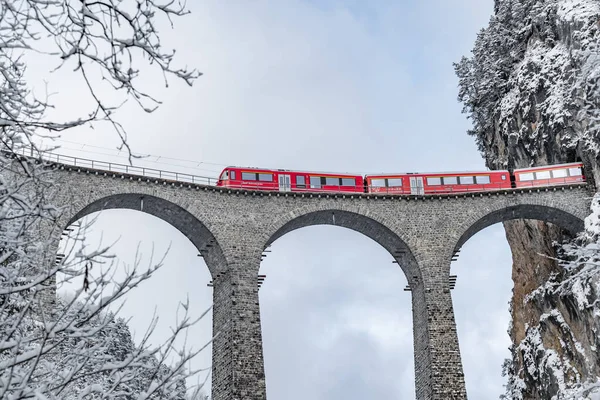 Il Landwasser Viadotto con famoso treno di colore rosso in inverno, punto di riferimento della Svizzera, nevicando, Ghiacciaio espresso — Foto Stock